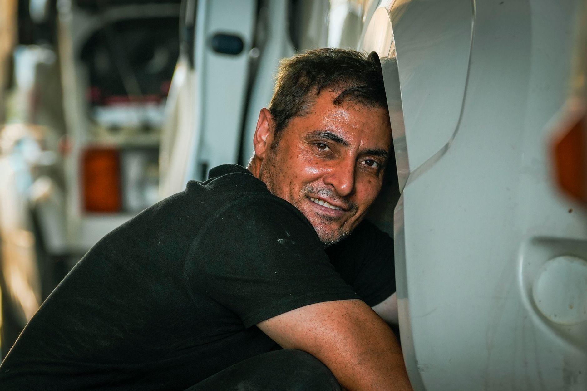 Portrait of a smiling mechanic performing repairs, adding a human touch to automotive maintenance.